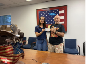 man and woman taking picture in front of the American flag